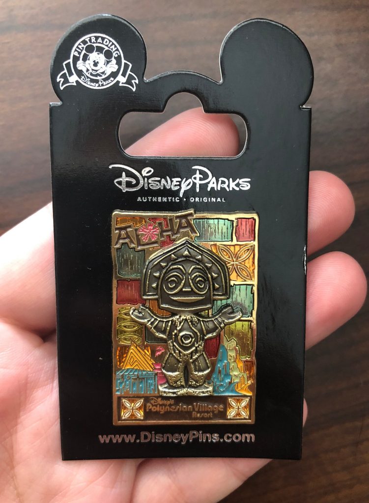Holding a Polynesian Village Resort pin at Walt Disney World