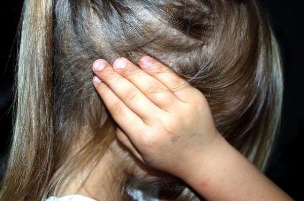 Child holding her ear in pain
