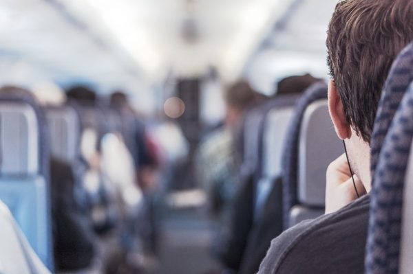 Passenger sitting on a plane with earbuds