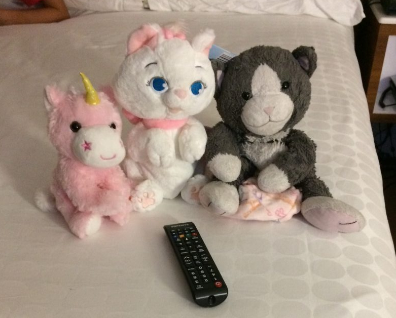 Mousekeeping arranging children's toys on the bed at Disney's Pop Century