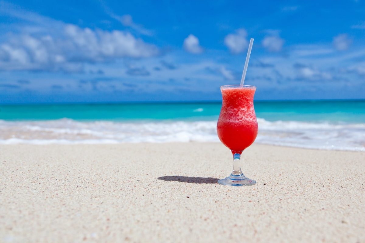 A drink sitting in the sand