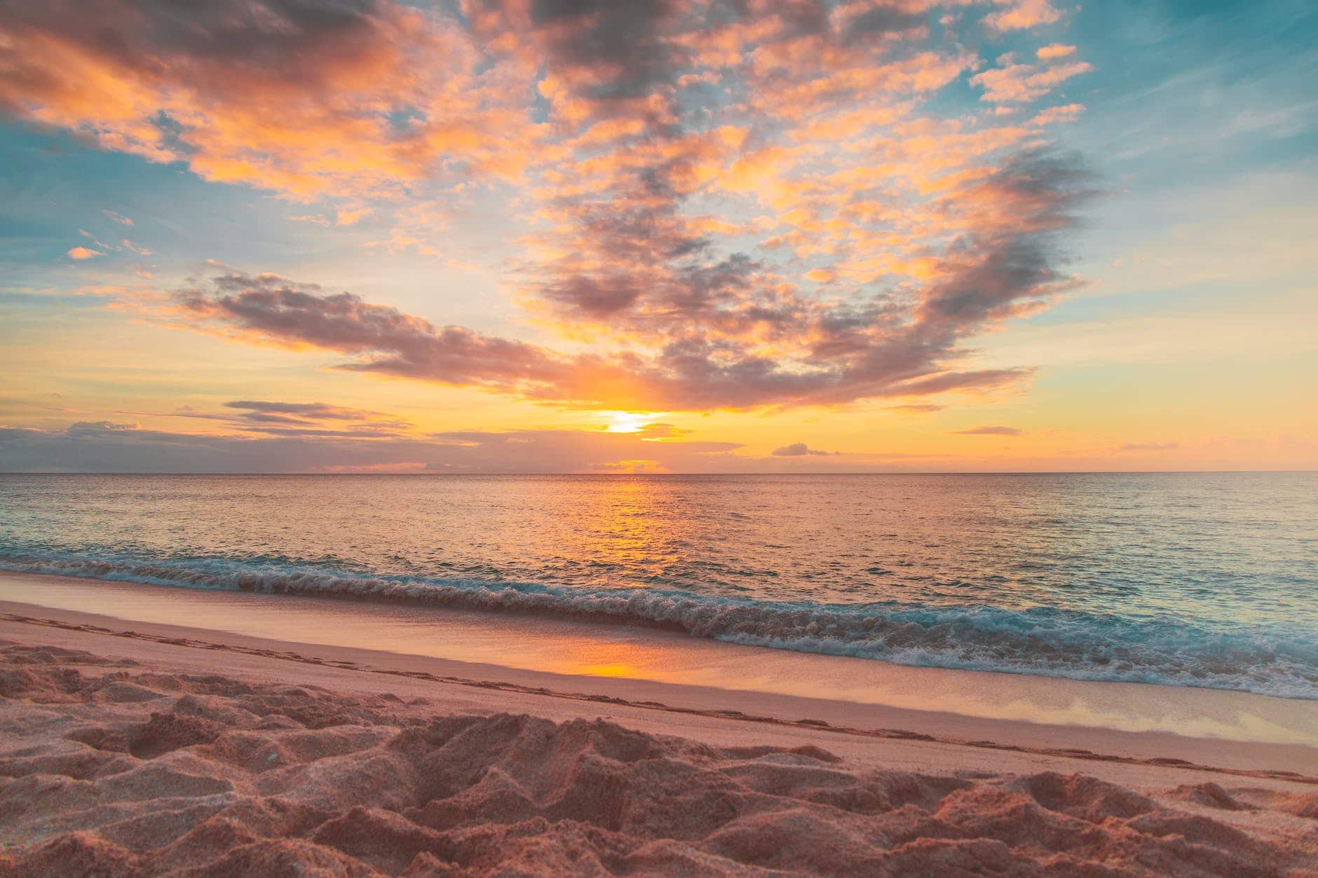 sea waves crashing on shore during sunset