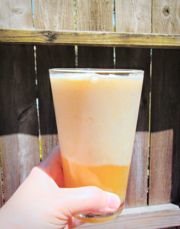 Holding up a melted glass of Dole Whip, made at home