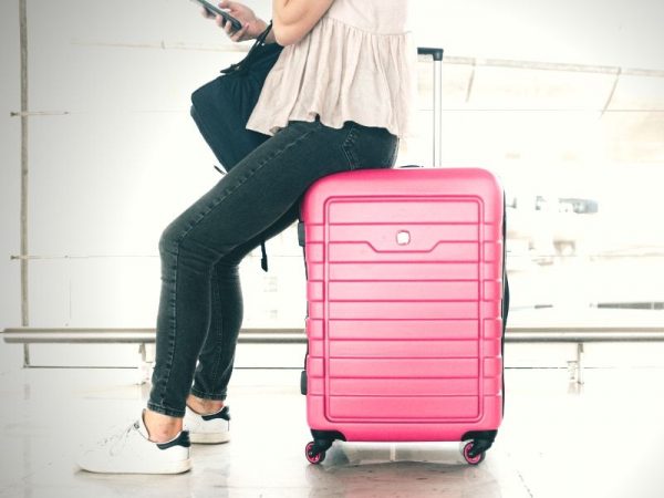 woman sitting on her luggage