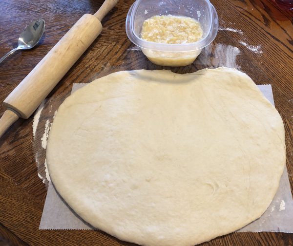 'Ohana Pineapple-Coconut Breakfast Bread dough flattened out with the pineapple and coconut mixture ready to be spread