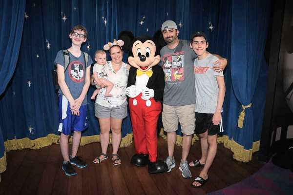 Family posing with Mickey Mouse in Epcot