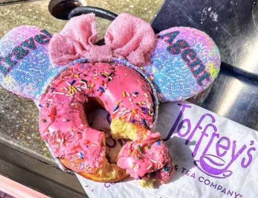 A set of Mickey ears with "Travel Agent" written on them with a pink donut, with sprinkles, from Joffrey's at Walt Disney World