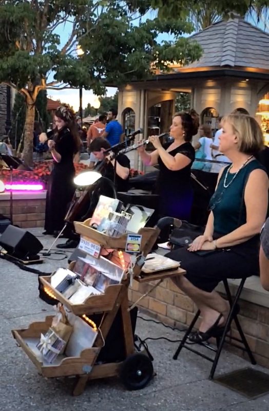 Women playing Disney music in Disney Springs to entertain Guests as they shop