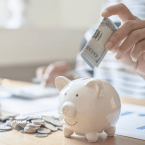 a picture of someone's hand putting money into a biggy pank