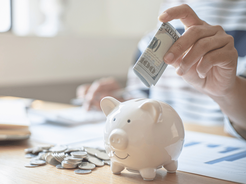 a picture of someone's hand putting money into a biggy pank