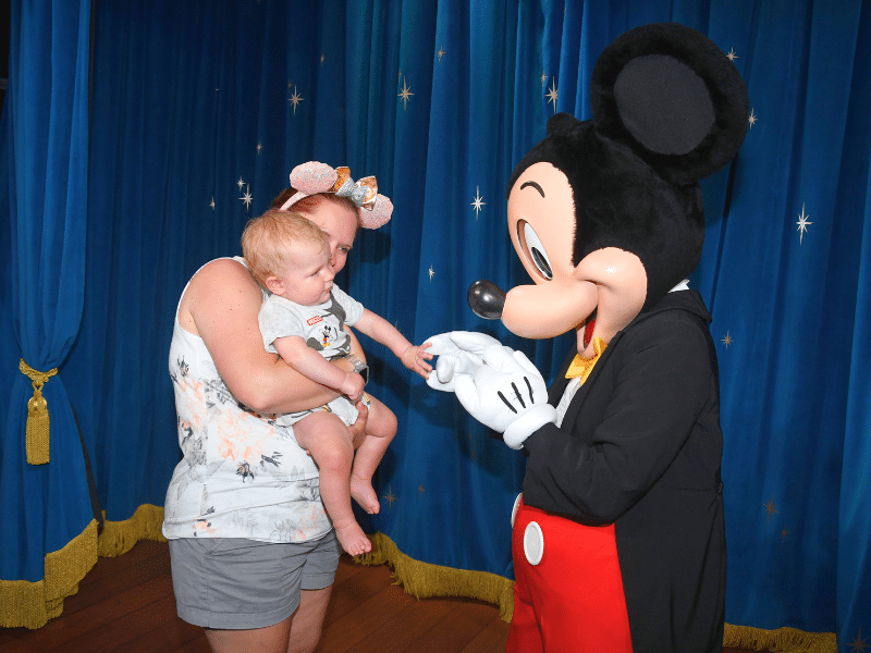 Mom and baby meeting Mickey Mouse in EPCOT